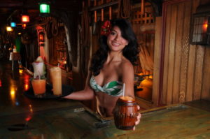 Sarong clad Mai-Kai maiden serves the Mai-Kai classic Barrel O’ Rum in signature barrel mug.