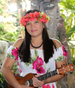 Rosemarie, a female musician playing her ukulele during a catering event.