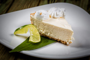 Key Lime Pie topped with whipped cream and a slice of lime.
